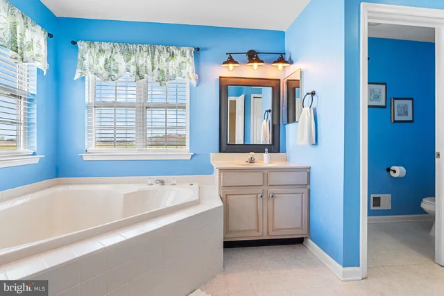 a bathroom with a tub sink and mirror
