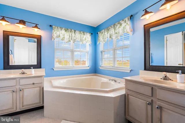 a bathroom with a tub a sink and mirror