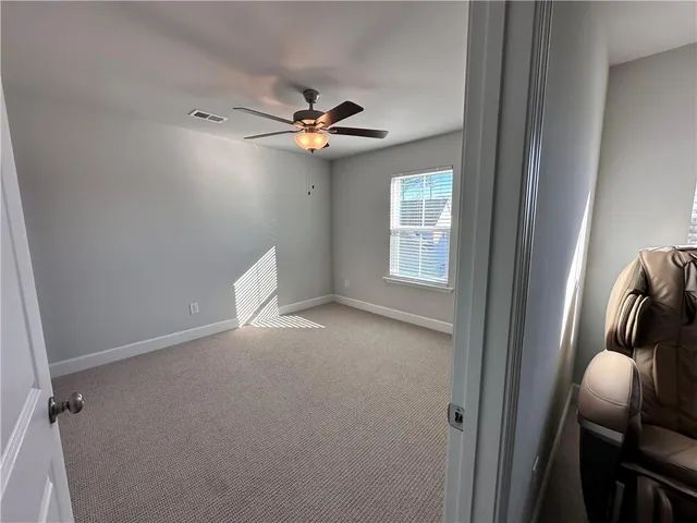 a view of a livingroom with a ceiling fan and window