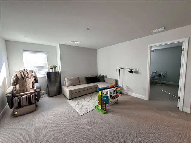 a living room with furniture a flat screen tv and a couch