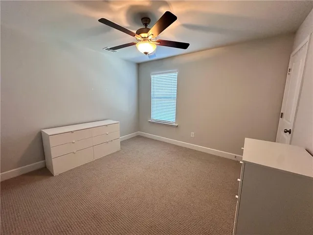 an empty room with a window and a ceiling fan