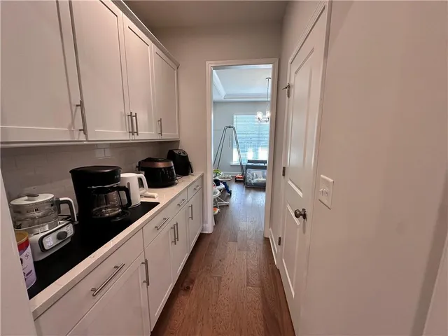 a kitchen with white cabinets and black appliances