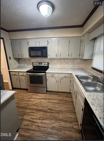 a kitchen with a sink stove and cabinets