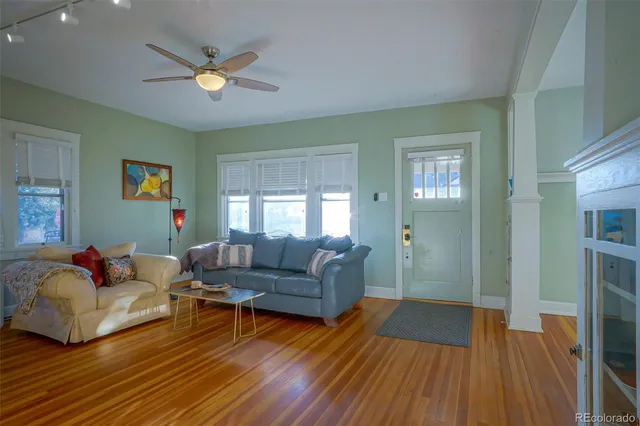 a living room with furniture and a wooden floor
