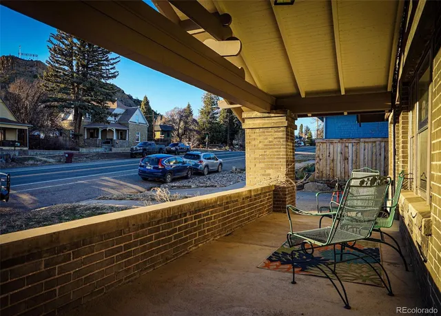 a view of a patio with table and chairs with wooden floor and fence