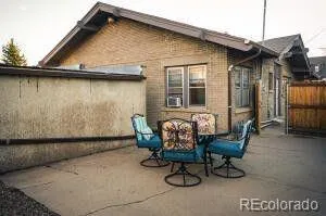 a view of brick house with outdoor seating space and wooden fence