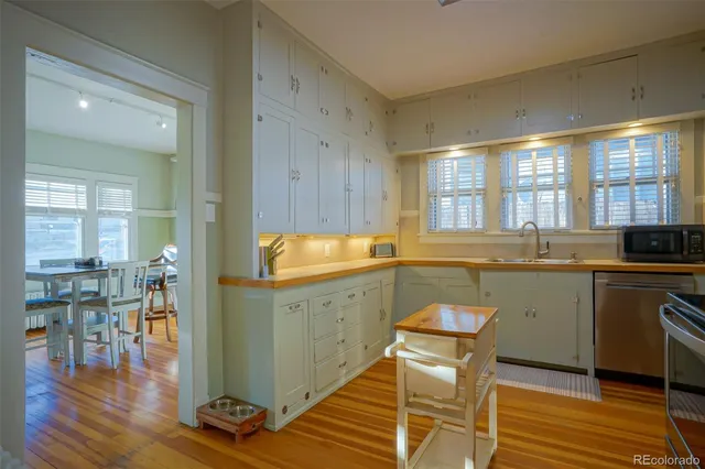 a kitchen with a sink cabinets and dining table chair