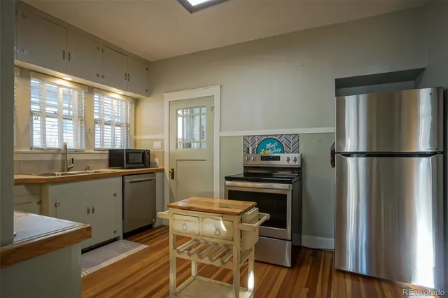 a kitchen with granite countertop a refrigerator stove top oven and sink