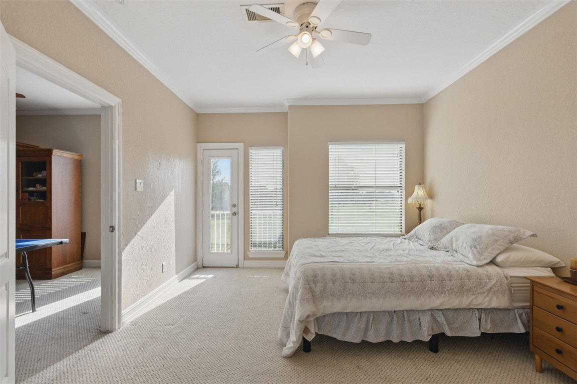90 Greenview Street Montgomery, TX 77356 - Photo 20 of 34 a bedroom with a bed and a chandelier