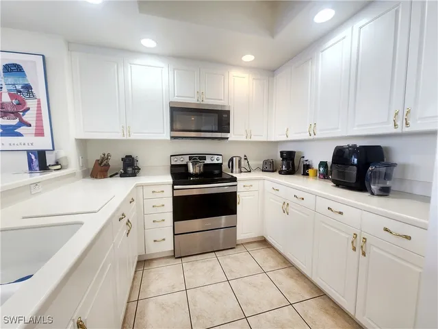 a kitchen with white cabinets stainless steel appliances and sink
