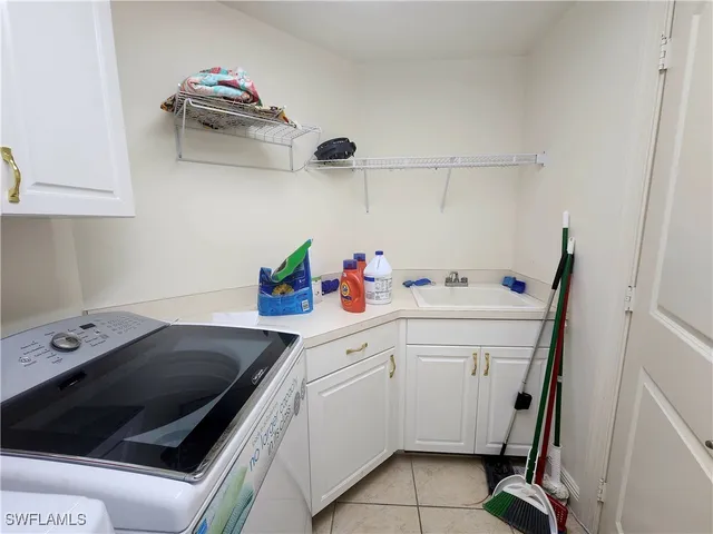 a utility room with sink dryer and washer