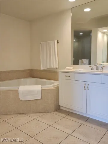a bathroom with a bathtub sink and mirror