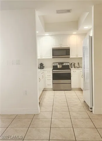 a kitchen with a stove top oven and cabinets