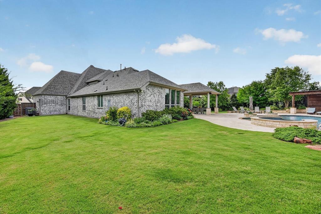 6656 Roughleaf Ridge Road Flower Mound, TX 76226 - Photo 36 of 40 a view of a house with a big yard and palm trees