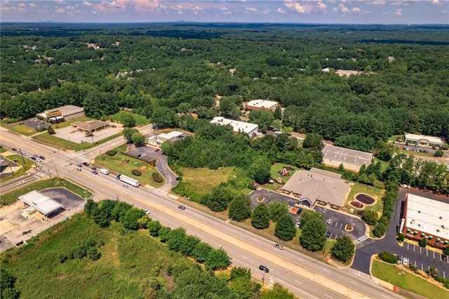 an aerial view of residential houses with outdoor space and trees