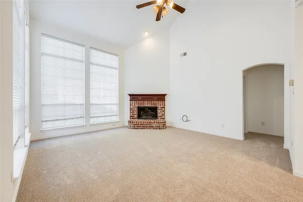 an empty room with windows and fireplace