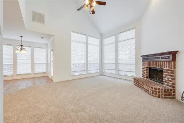 a view of an empty room with a fireplace and a window