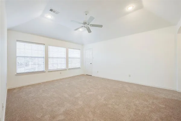 an empty room with a window and a fan