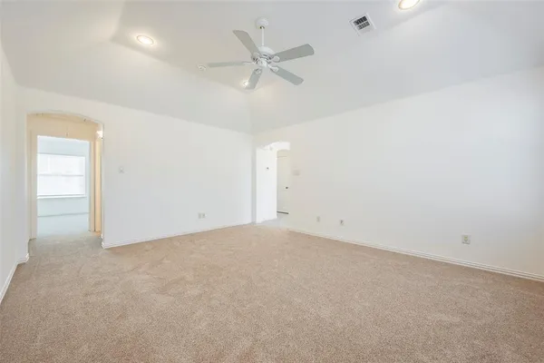 an empty room with a ceiling fan and a window