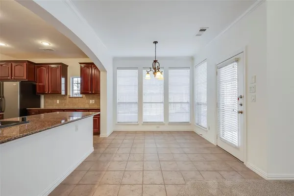 a large kitchen with granite countertop a large counter top space a sink stainless steel appliances and cabinets