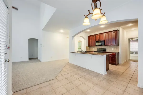 a kitchen with stainless steel appliances kitchen island granite countertop a refrigerator a stove a sink and a microwave