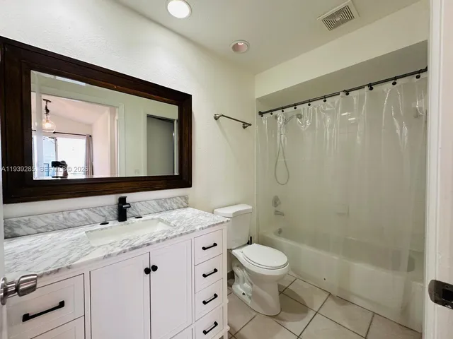 a view of an empty room and kitchen view