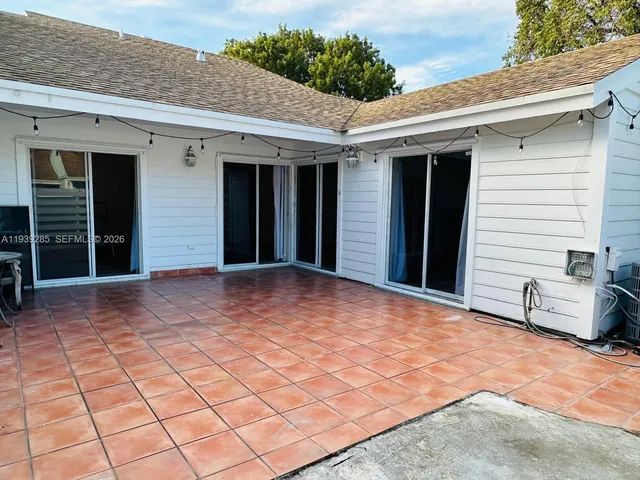 a view of a house with backyard and sitting area