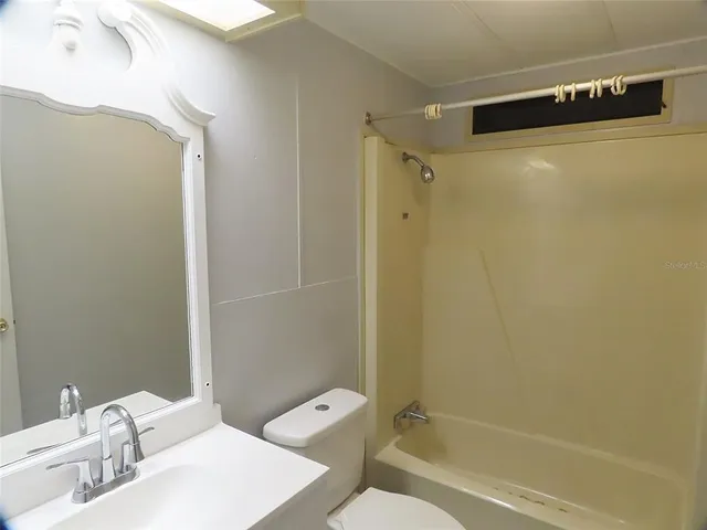 a view of an empty room with wooden floor and windows