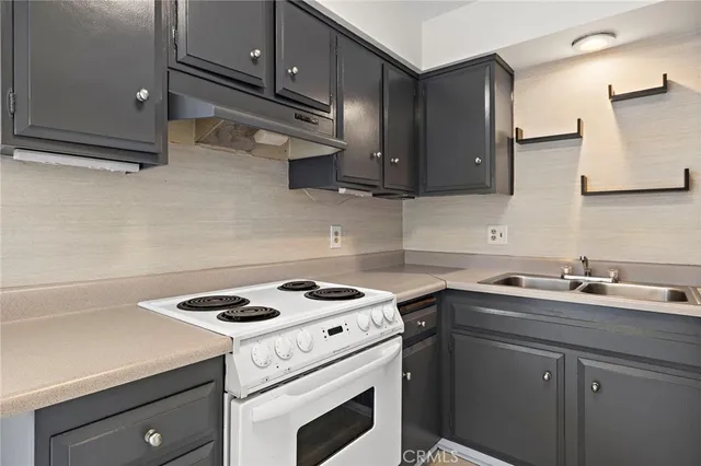 a kitchen with a sink a stove and cabinets