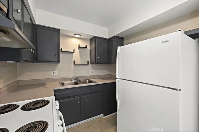 a kitchen with a sink a refrigerator and cabinets