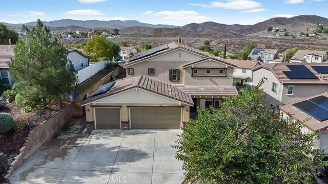 an aerial view of a house with a mountain