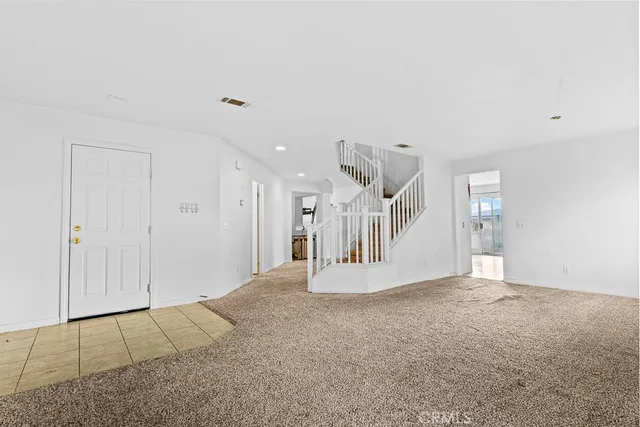 a view of an empty room with staircase