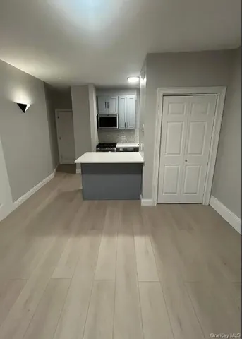 a view of a kitchen with kitchen island a sink wooden floor and a refrigerator