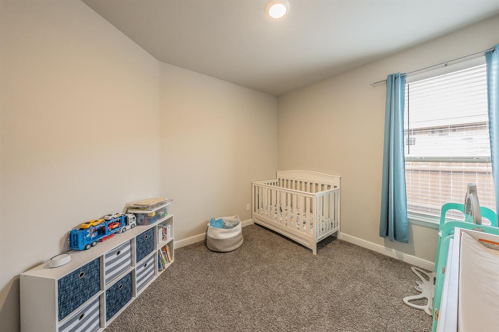 1212 Bosque Lane Weatherford, TX 76087 - Photo 31 of 38 a room with a baby crib and a wooden floor