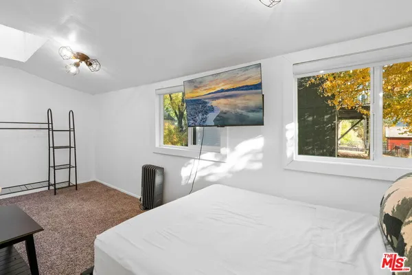 a bedroom with a bed and a large window