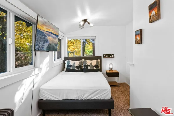 a bed room with a bed and a painting on the wall