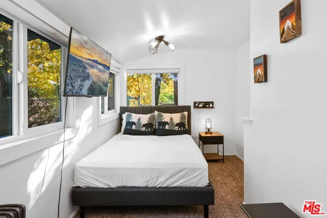 a bed room with a bed and a painting on the wall