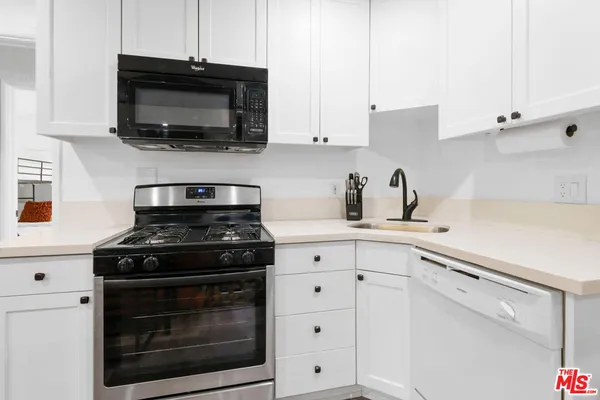 a kitchen with stainless steel appliances white cabinets and a stove a oven