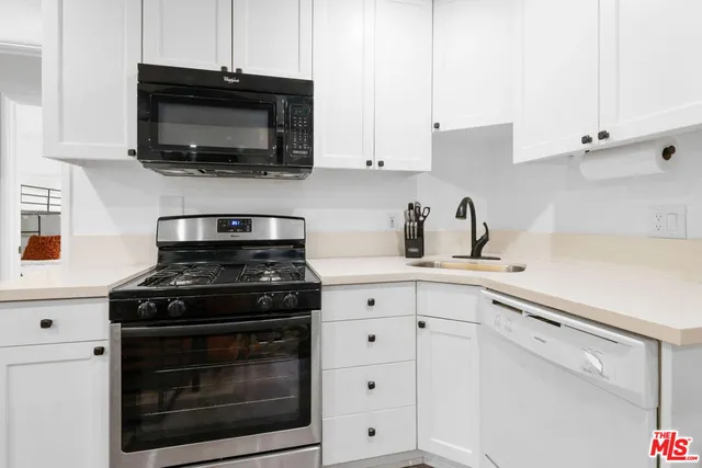 a kitchen with stainless steel appliances white cabinets and a stove a oven