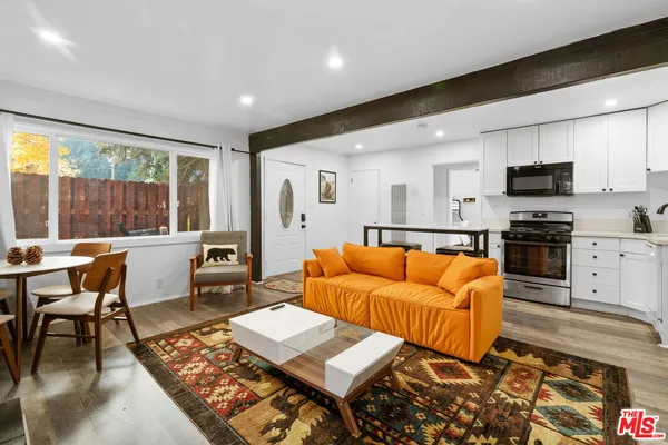 a living room with furniture a flat screen tv and a large window