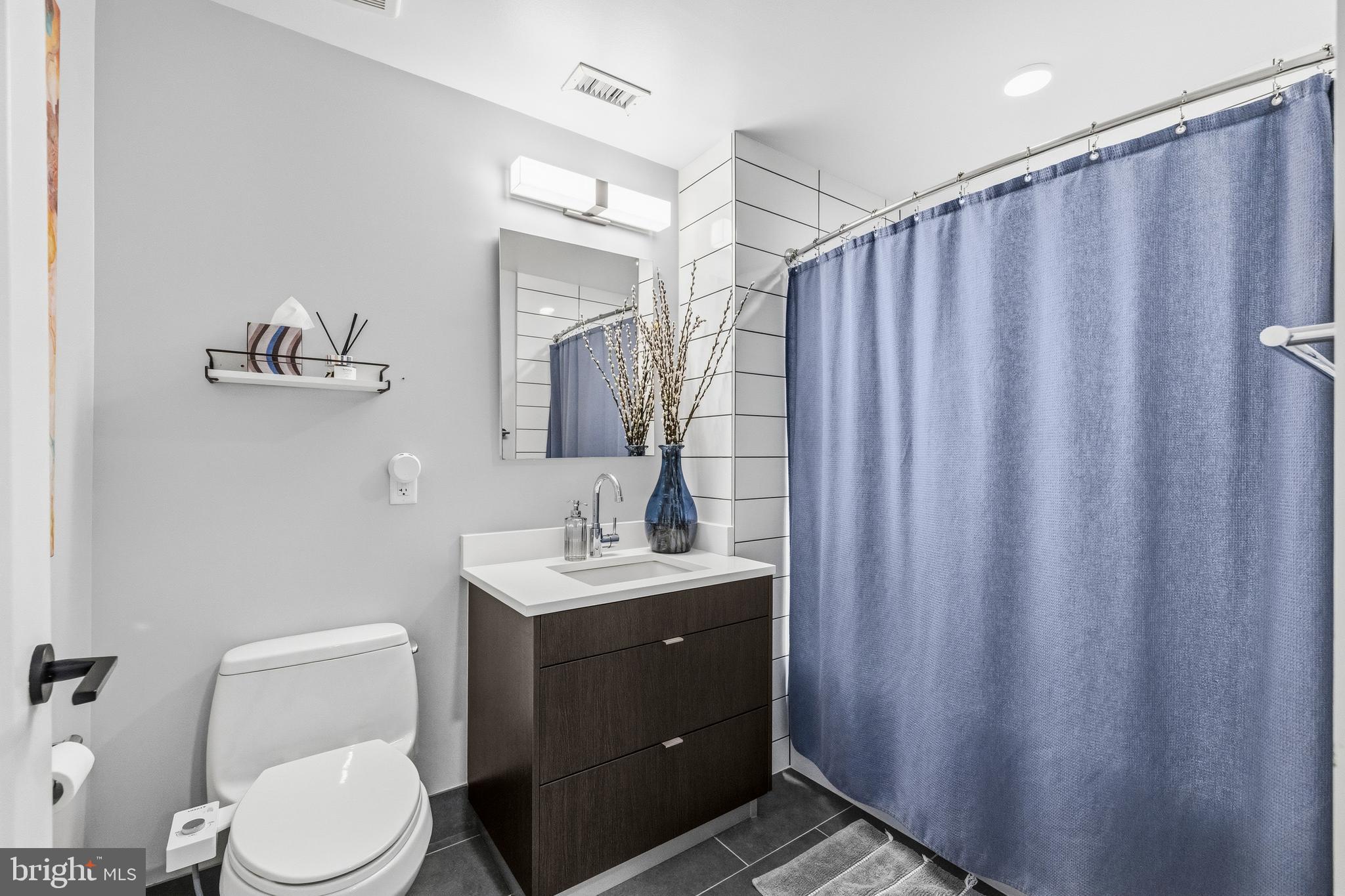 1300 4th Street Southeast, Unit 303 Washington, DC 20003 - Photo 17 of 42 a bathroom with a toilet a sink and a mirror