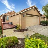 a front view of a house with a yard and potted plants