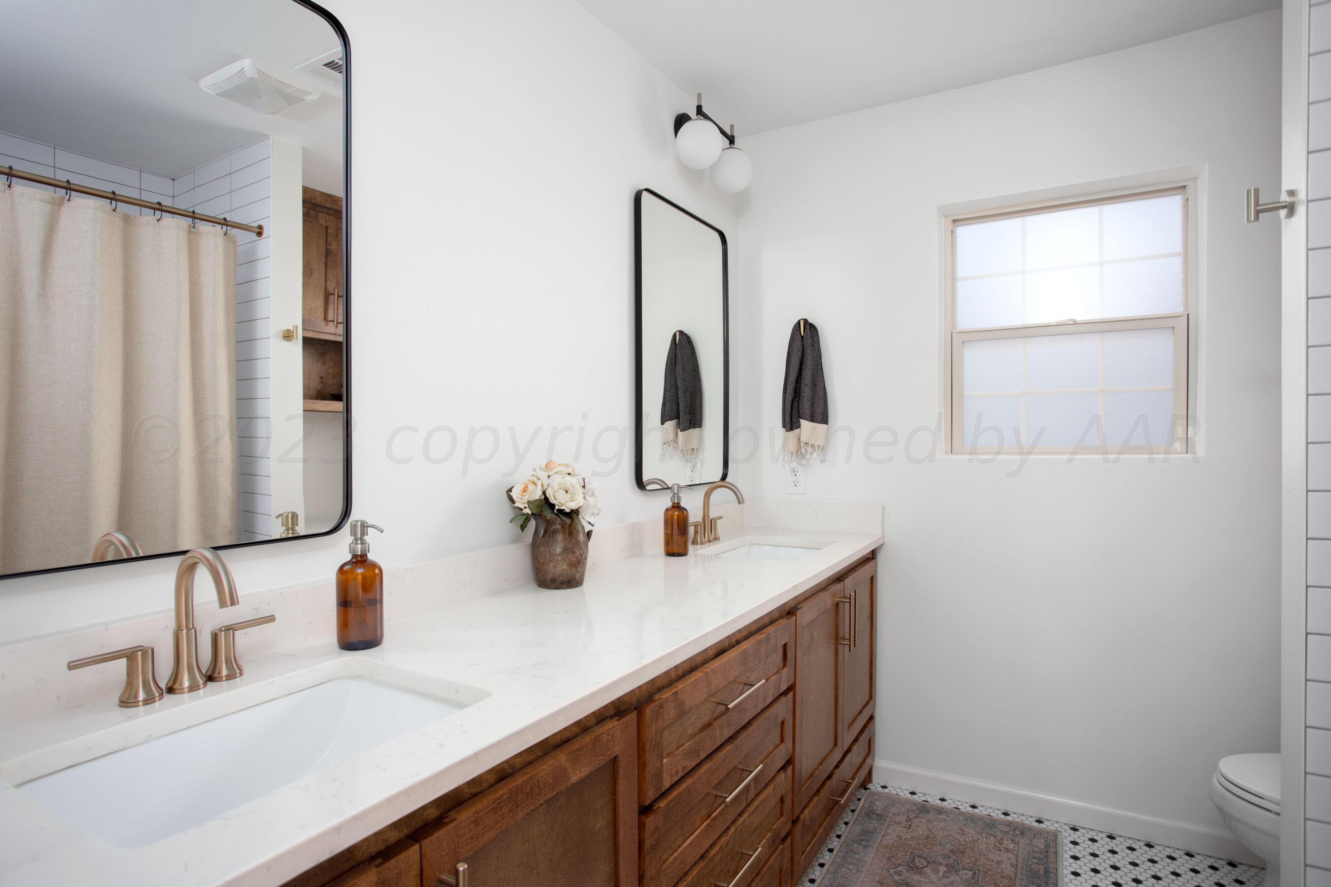 6302 Calumet Road Amarillo, TX 79106 - Photo 19 of 33 a bathroom with double vanity sink a mirror and a toilet
