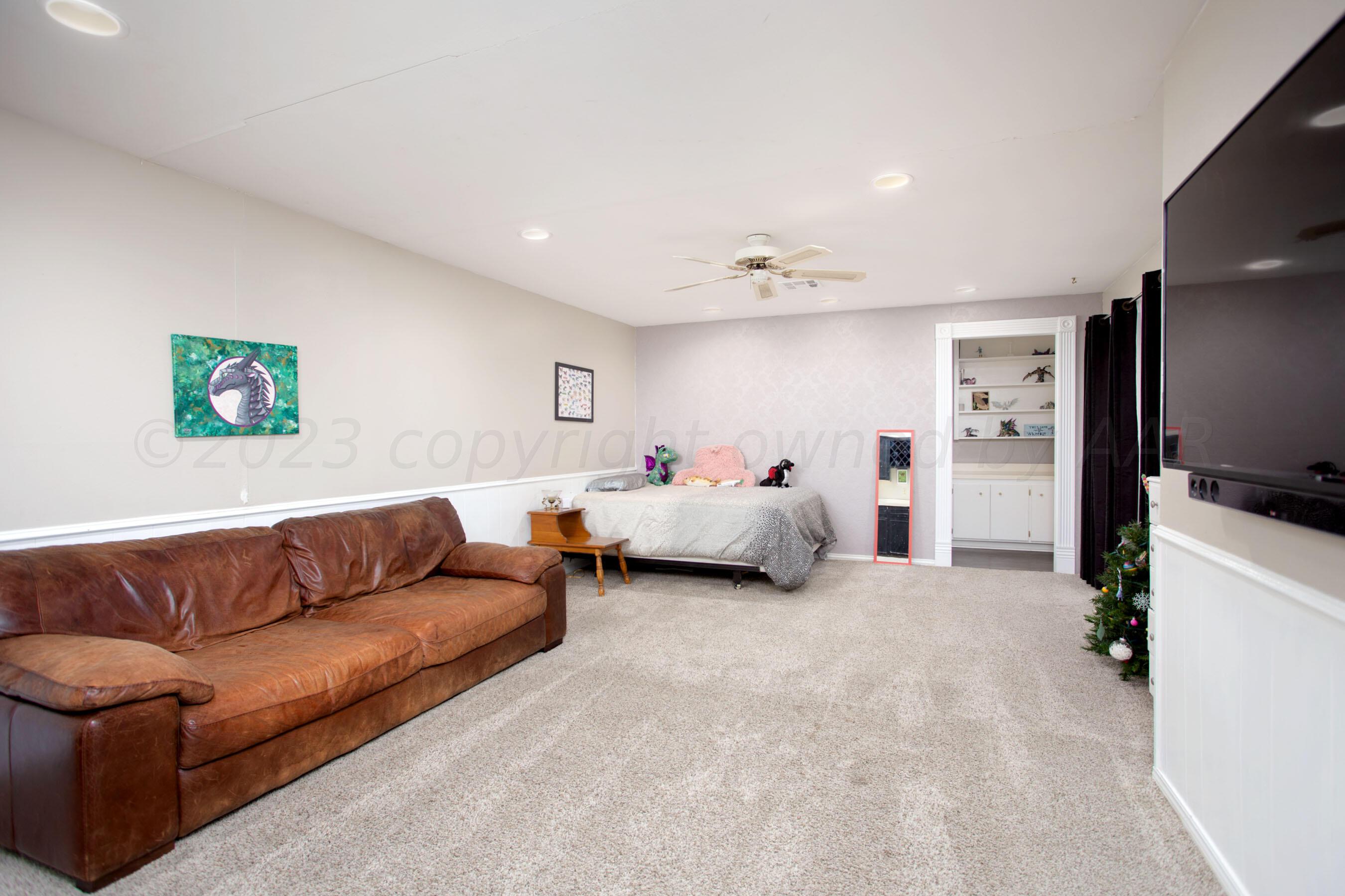 6302 Calumet Road Amarillo, TX 79106 - Photo 24 of 33 a spacious bedroom with a bed couch and a view of living room