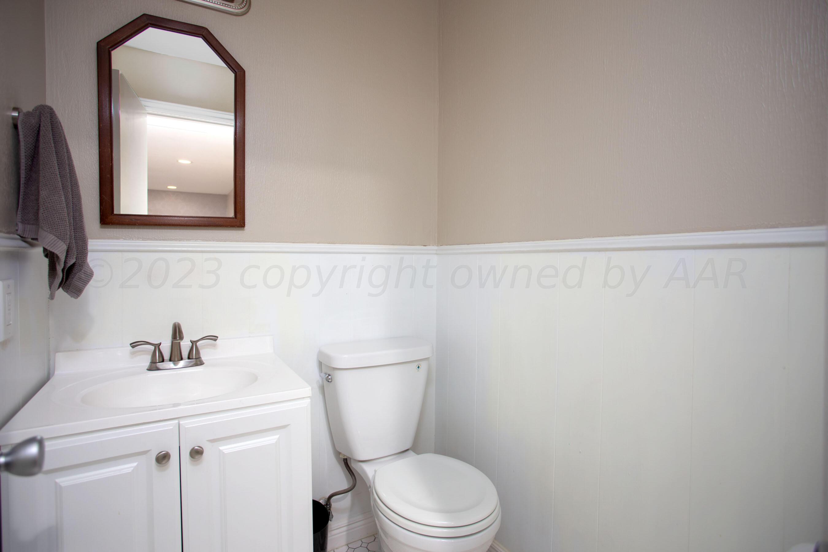 6302 Calumet Road Amarillo, TX 79106 - Photo 26 of 33 a bathroom with a toilet a sink and mirror