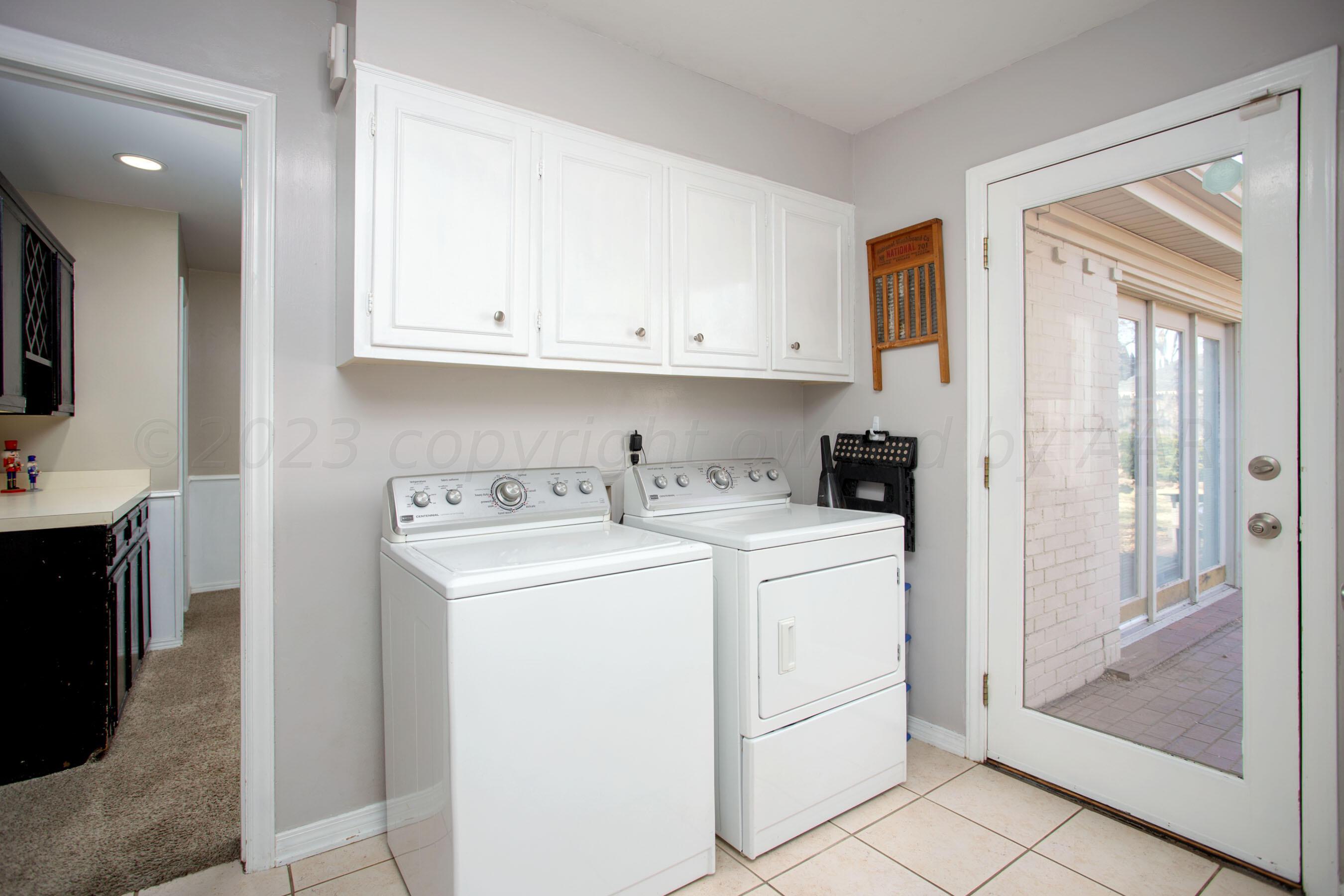 6302 Calumet Road Amarillo, TX 79106 - Photo 29 of 33 a view of washer and dryer with white cabinets