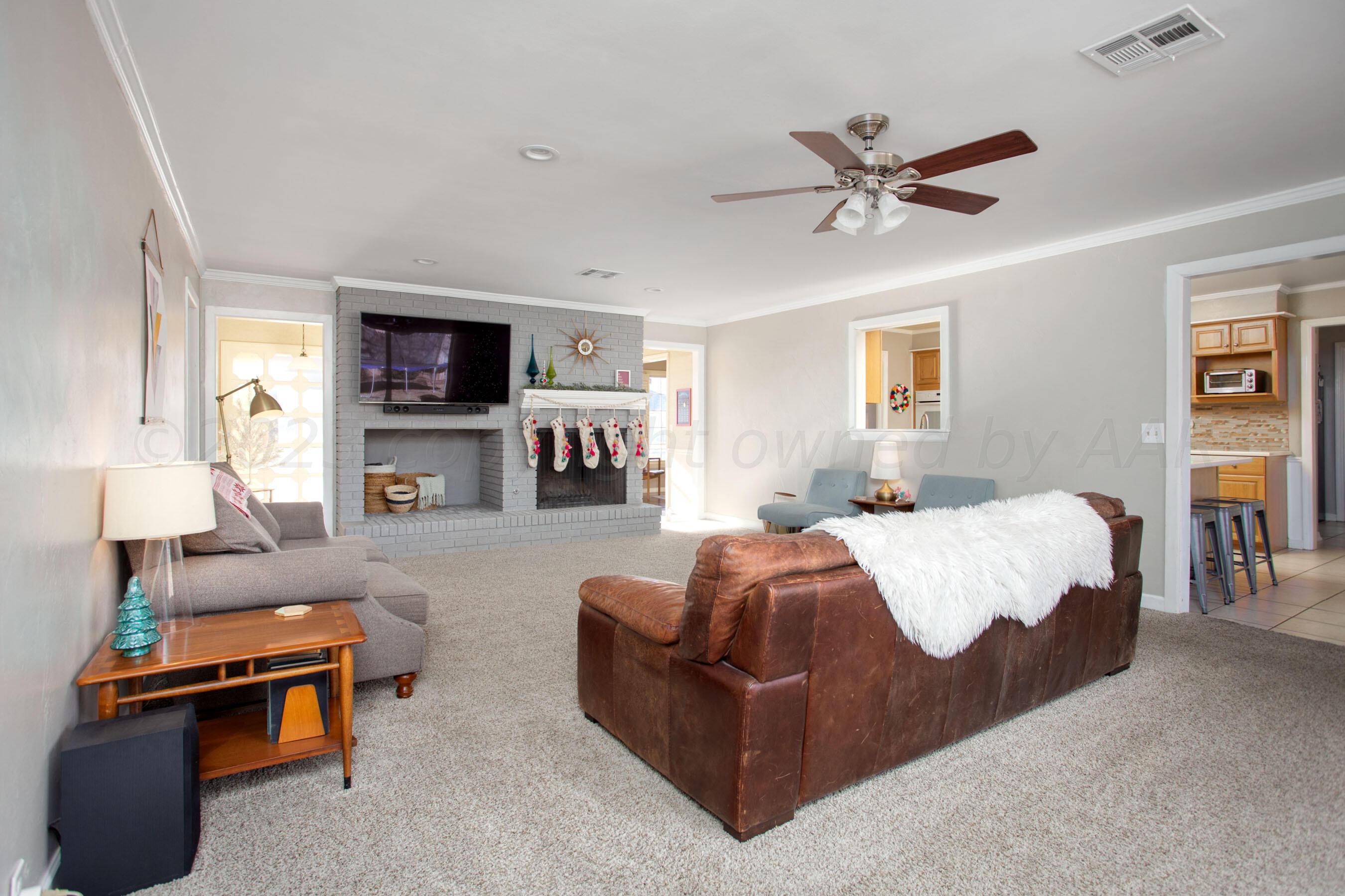 6302 Calumet Road Amarillo, TX 79106 - Photo 8 of 33 a spacious bedroom with a bed a couch and a flat tv screen