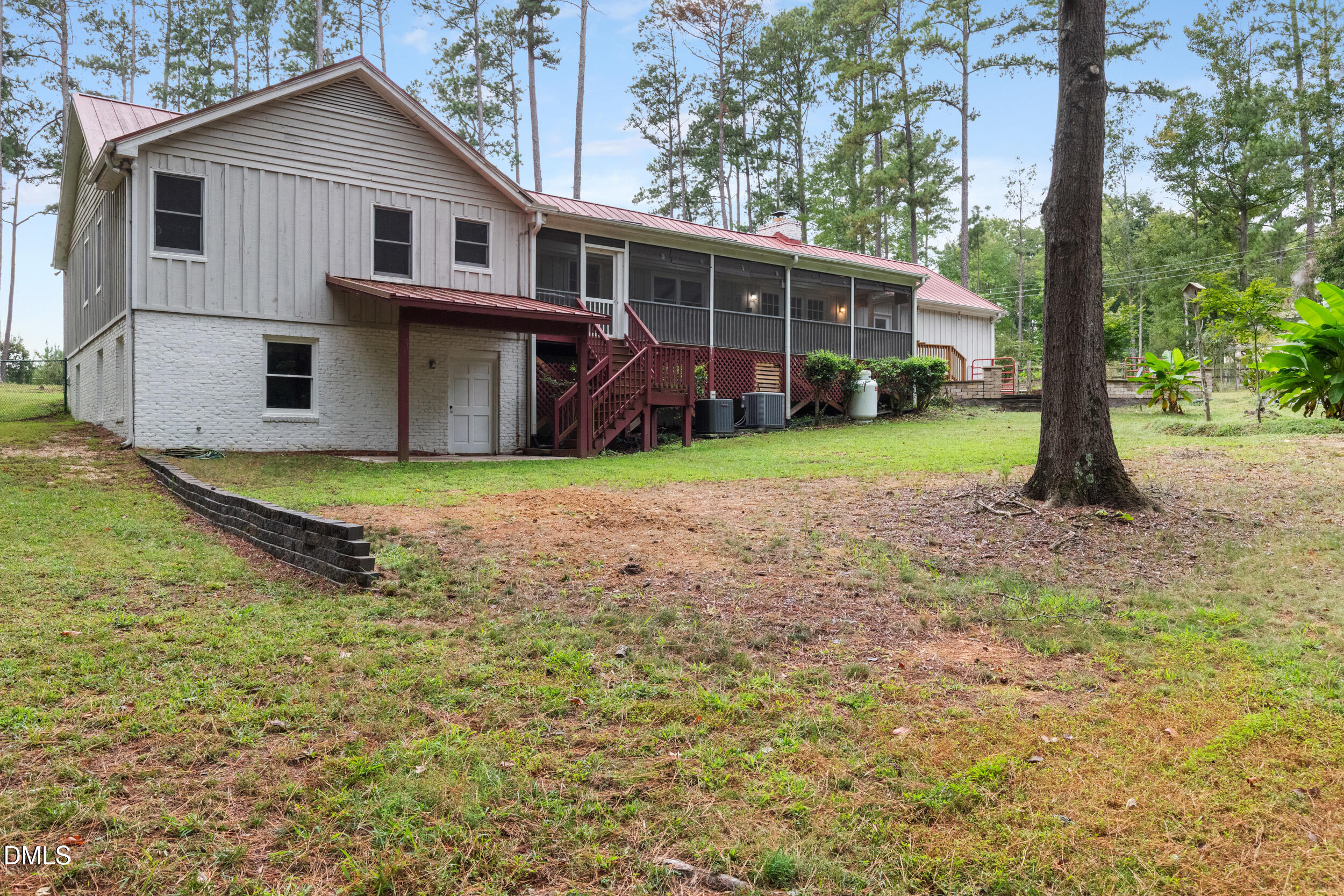 2329 Win Road Garner, NC 27529 - Photo 8 of 90 Exterior featuring a screened porch, red metal roof, white brick foundation, and a covered ground-level entry