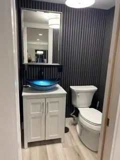 a bathroom with a granite countertop sink a toilet and mirror