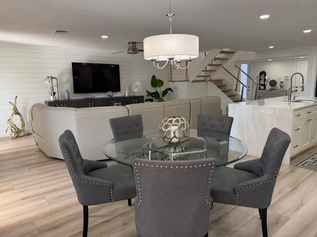 a living room with furniture a flat screen tv and kitchen view